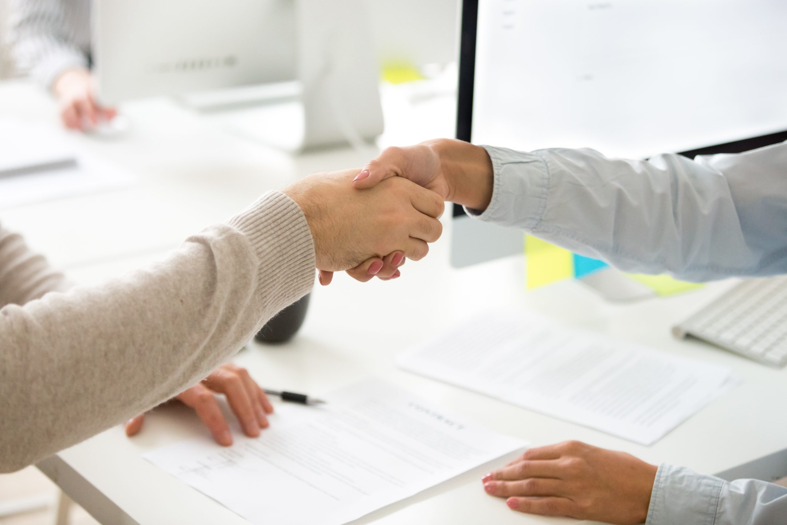 Handshake of man and woman after signing business contract, clos